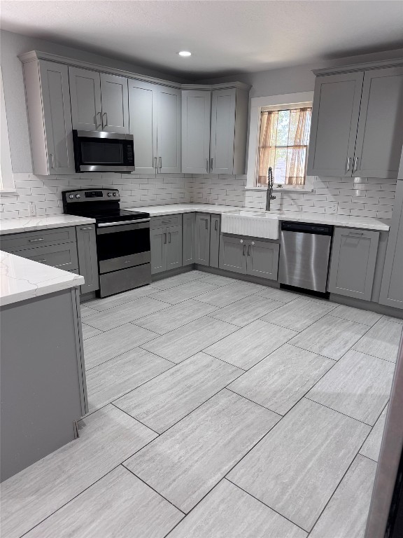 939 Knape Road La Grange, TX 78945 - Photo 34 of 37 Kitchen featuring gray cabinets, stainless steel appliances, tasteful backsplash, light stone counters, and recessed lighting