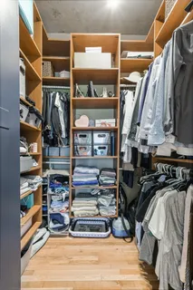 a view of walk in closet with clothes and shoes
