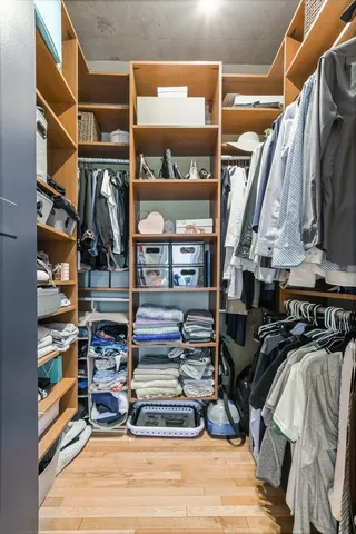 a view of walk in closet with clothes and shoes