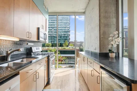 a kitchen with kitchen island granite countertop a sink appliances cabinets and a counter top space
