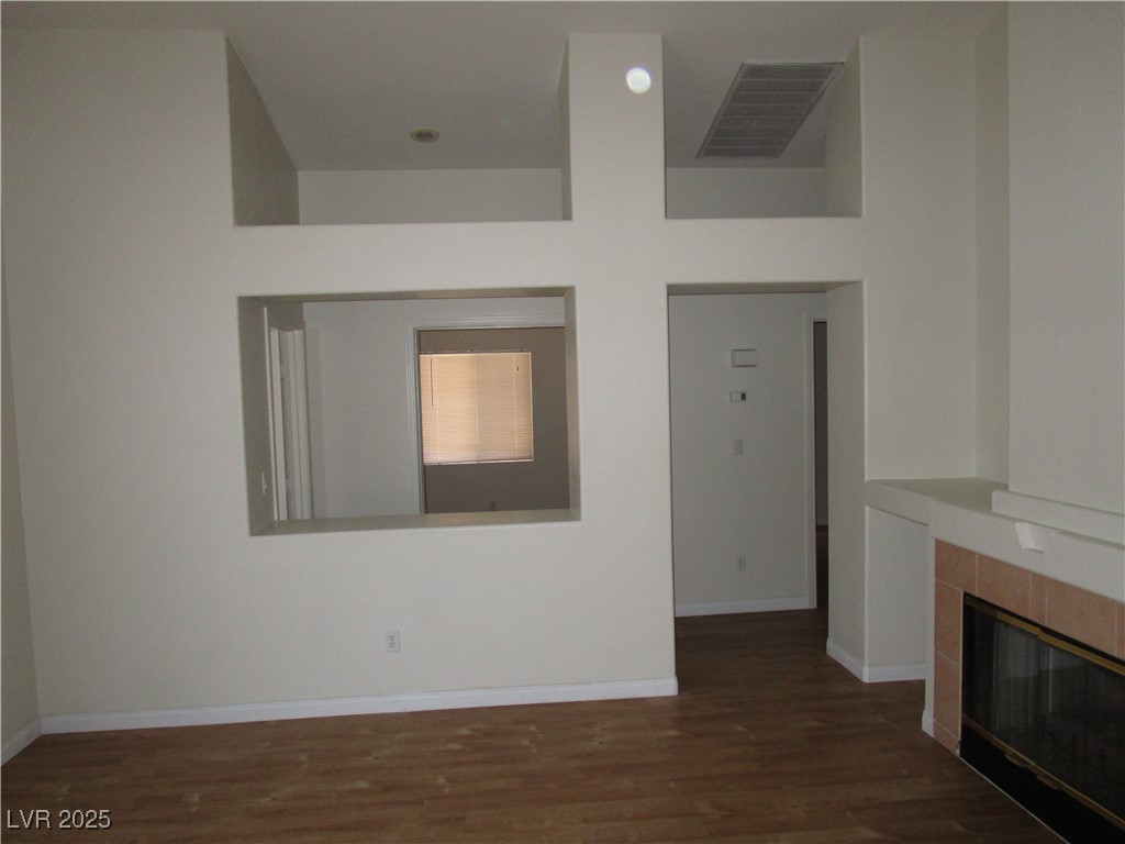 1966 Windfall Avenue Henderson, NV 89012 - Photo 11 of 13 Unfurnished living room featuring a tiled fireplace and wood finished floors