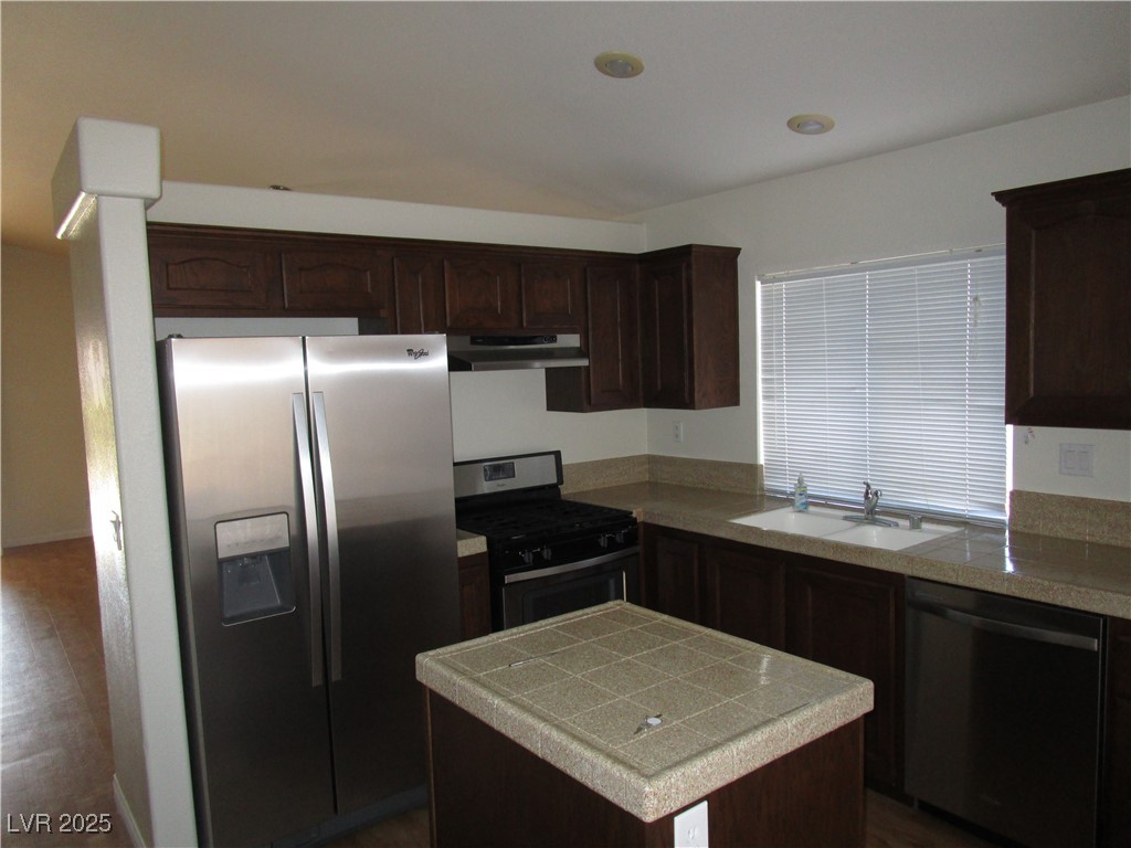 1966 Windfall Avenue Henderson, NV 89012 - Photo 4 of 13 Kitchen featuring stainless steel appliances, dark brown cabinetry, under cabinet range hood, and a center island