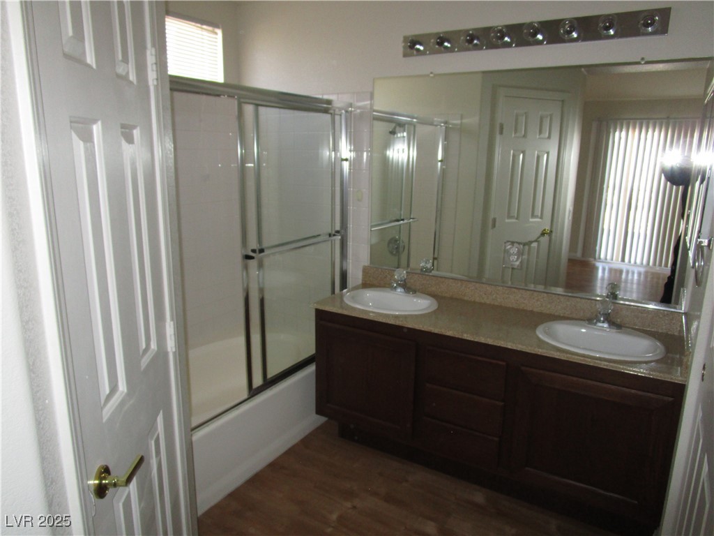 1966 Windfall Avenue Henderson, NV 89012 - Photo 8 of 13 Full bath with double vanity, combined bath / shower with glass door, and wood finished floors