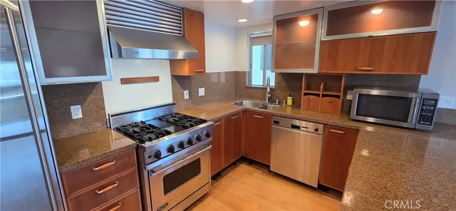 a kitchen with stainless steel appliances granite countertop a stove and a sink