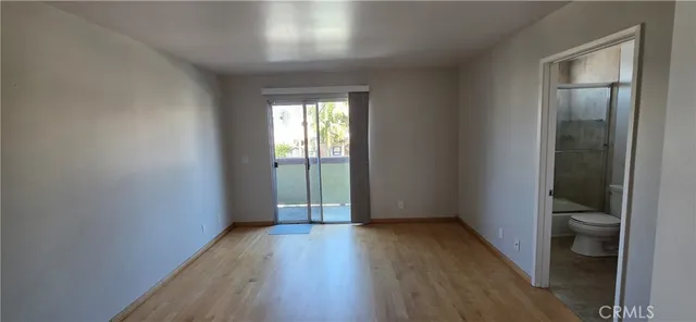 an empty room with wooden floor and a window