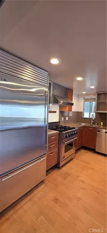 a kitchen with stainless steel appliances kitchen island granite countertop a stove and a microwave