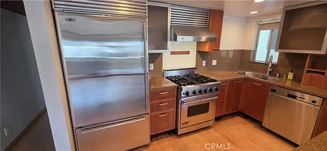 a kitchen with stainless steel appliances granite countertop a refrigerator stove and sink