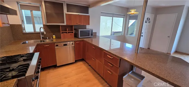a kitchen with stainless steel appliances granite countertop a stove a sink and a refrigerator