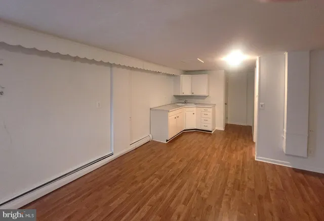 a view of a kitchen with wooden floor and a sink