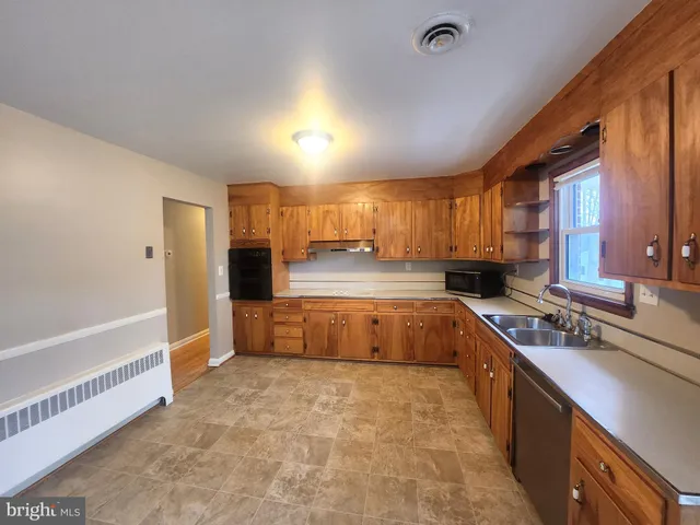 a large kitchen with stainless steel appliances granite countertop a stove a sink dishwasher and a refrigerator