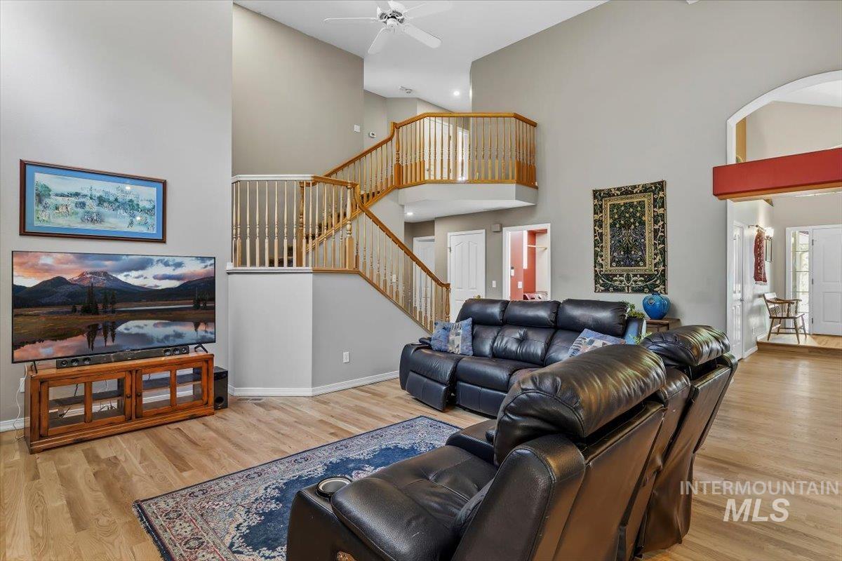 8001 West Innsbrook Court Boise, ID 83704 - Photo 10 of 39 Living area featuring vaulted ceilings, a two-story staircase with wood railing, recessed lighting, and wood-finish flooring