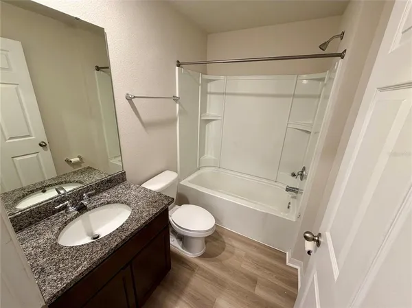 a bathroom with a sink toilet a mirror and shower