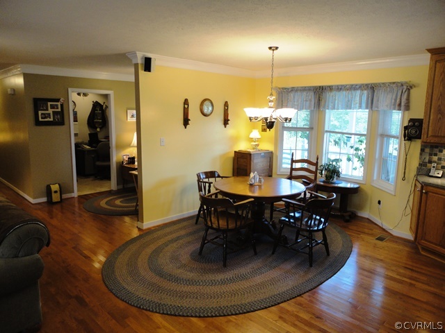 1585 Copper Line Road Bumpass, VA 23024 - Photo 9 of 24 a dining room with furniture a chandelier and wooden floor