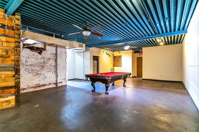 an outdoor sitting area with couch and wooden shade