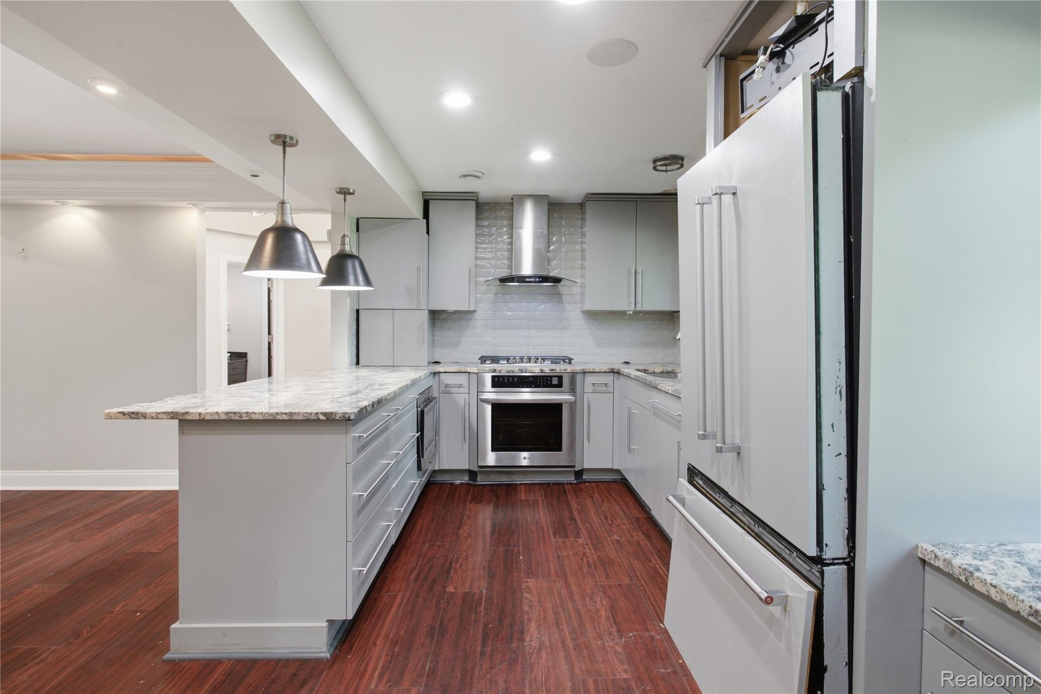 3812 Terrybrook Road West Bloomfield, MI 48322 - Photo 11 of 43 Contemporary kitchen featuring light gray cabinetry, stainless steel appliances, granite countertops, and a subway tile backsplash