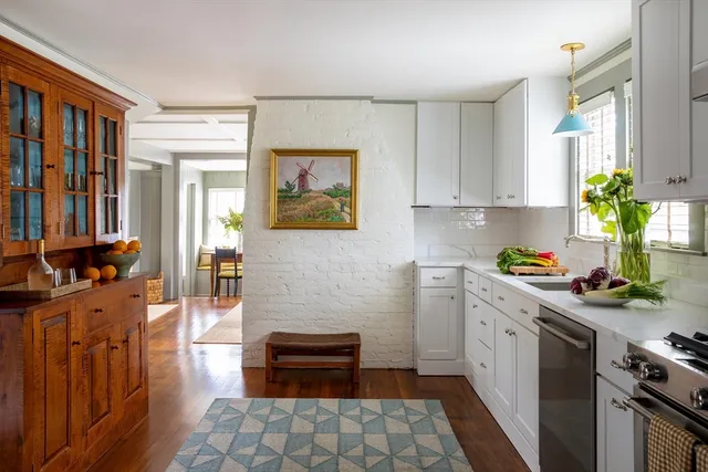 a kitchen with stainless steel appliances a stove top oven a sink a counter space and cabinets