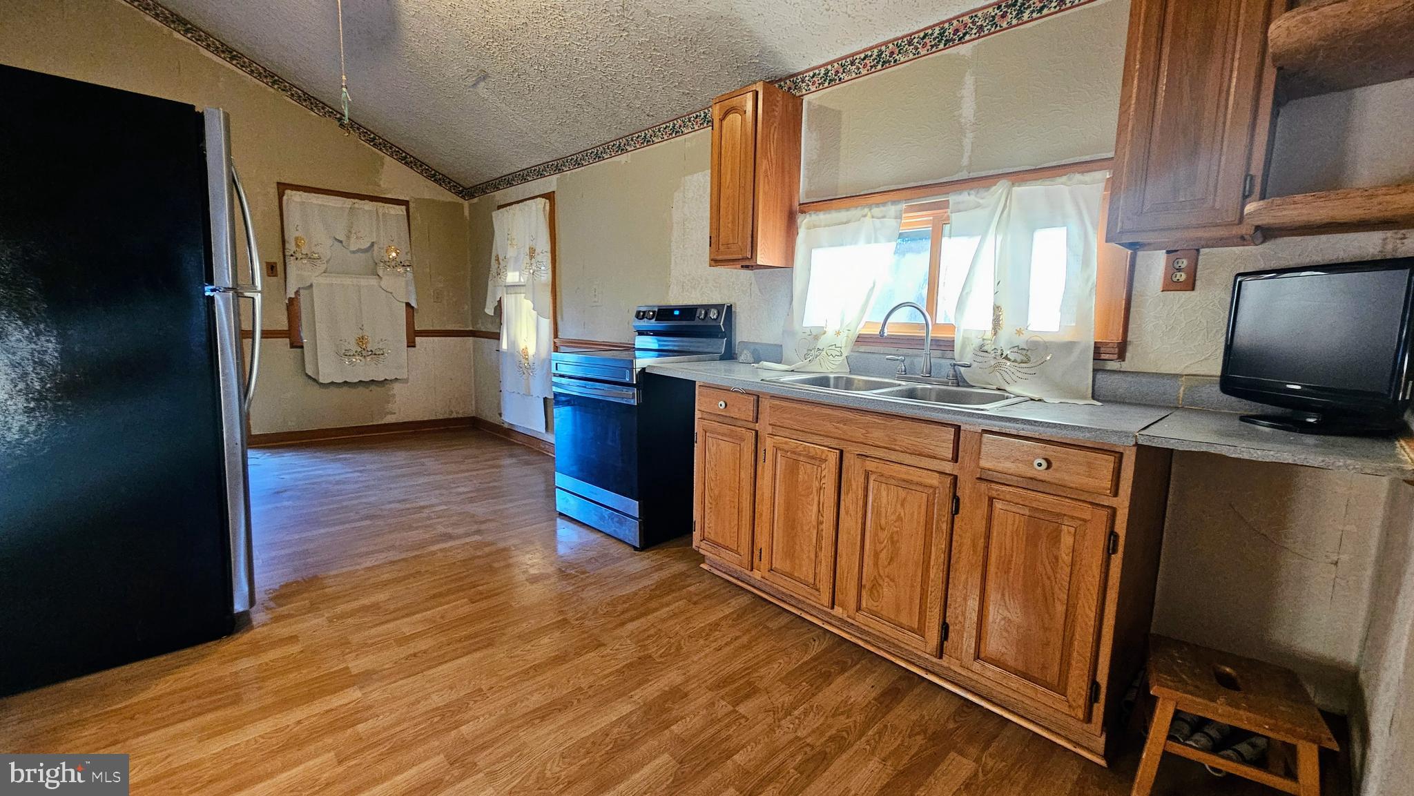 1535 Erney Road Dover, PA 17315 - Photo 9 of 20 a kitchen with stainless steel appliances granite countertop a refrigerator a sink dishwasher and wooden cabinets with wooden floor