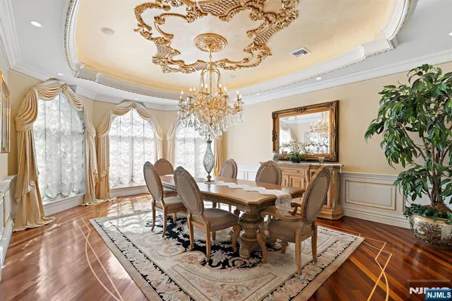 a view of a hallway with wooden floor and chandelier