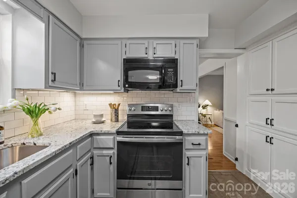 a kitchen with a stove and a white cabinets