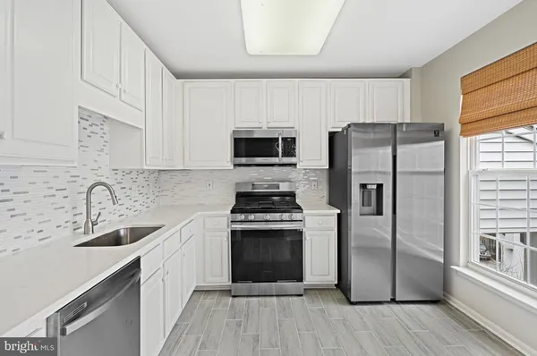 a kitchen with cabinets stainless steel appliances and a counter space
