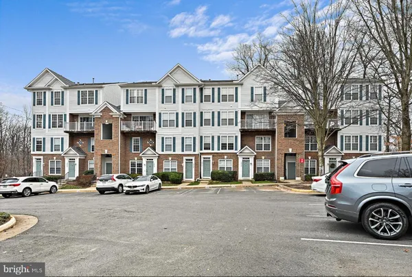 a front view of a residential apartment building with parking space
