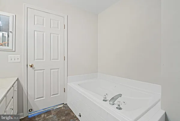 a bathroom with a sink vanity and tub