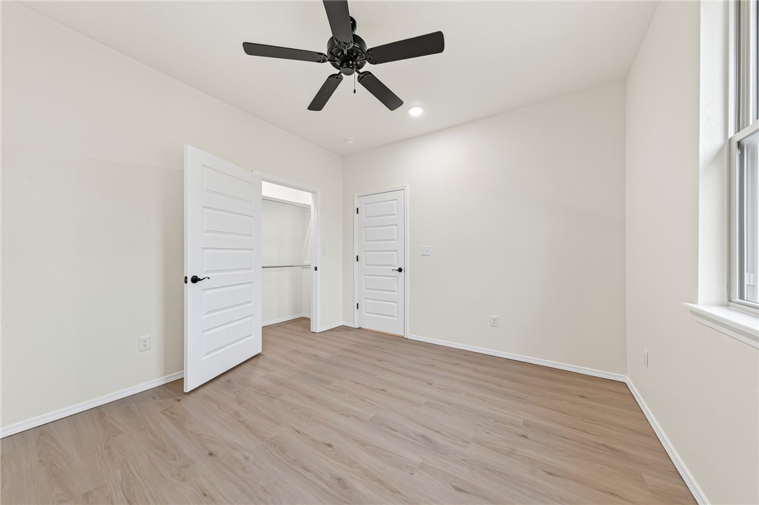 6138 New Hope Road Hackett, AR 72937 - Photo 20 of 56 Vaulted ceiling with an attached ceiling fan, wood-finish flooring, and white paneled doors