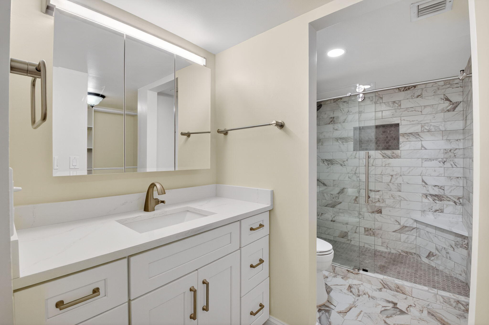 159 Northwest 70th Street, Unit 403 Boca Raton, FL 33487 - Photo 13 of 31 a bathroom with a sink a toilet a shower and a mirror