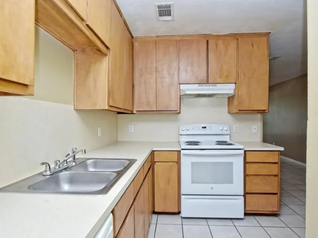 a kitchen with sink a stove and cabinets