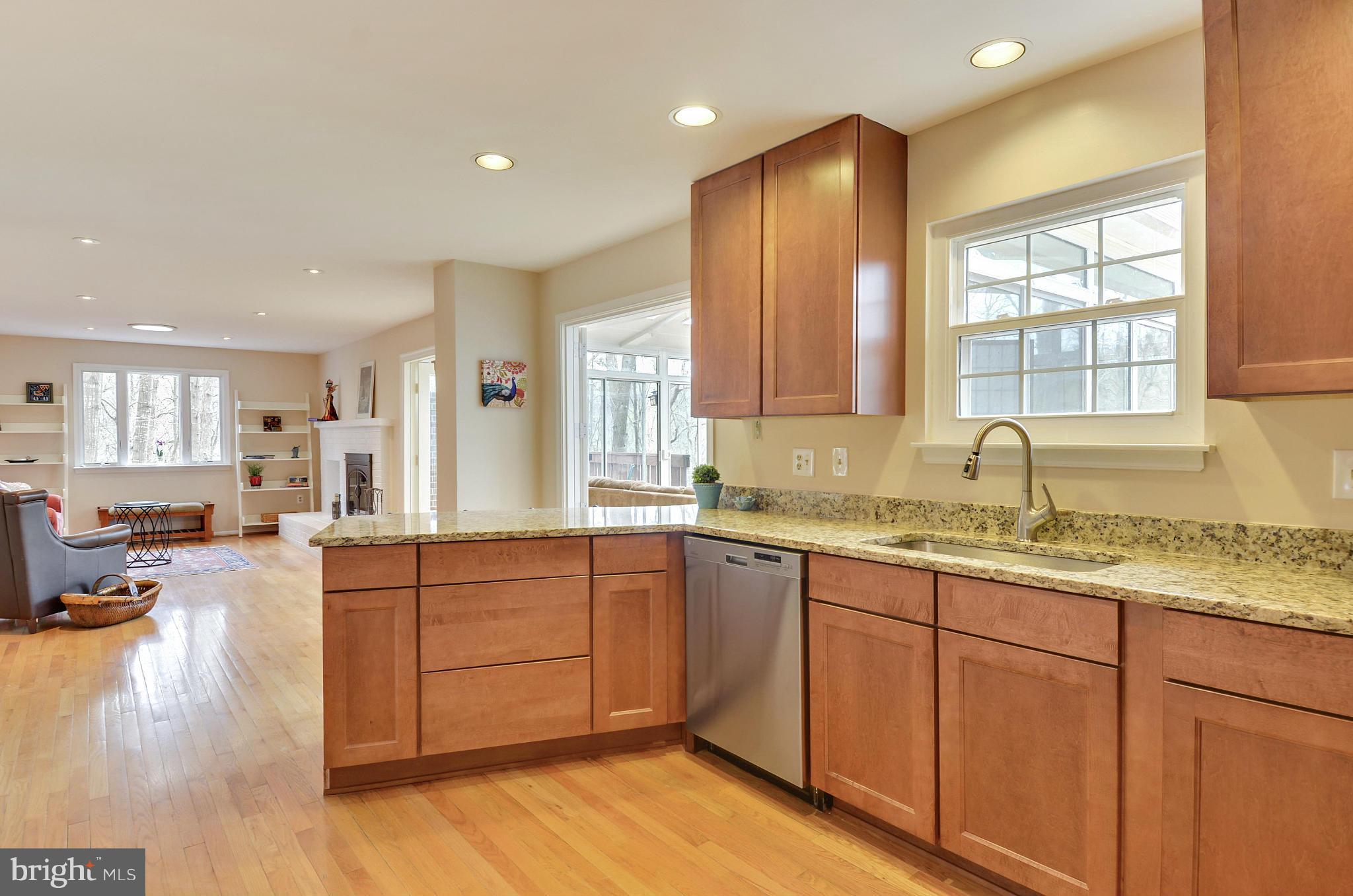 1922 Buckthorn Lane Reston, VA 20191 - Photo 9 of 30 a large kitchen with kitchen island a sink dishwasher a stove and white cabinets with wooden floor