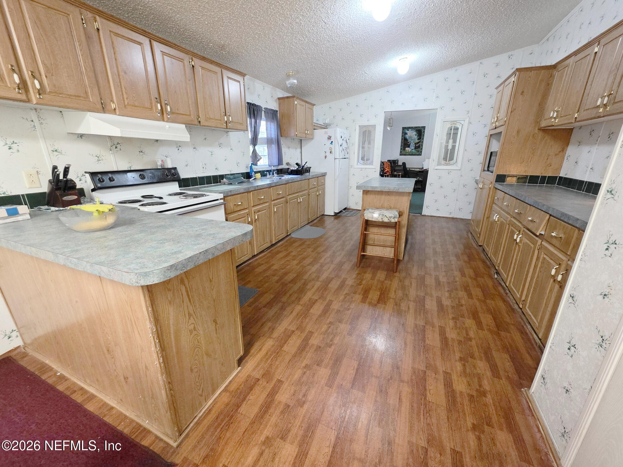 44680 Artesian Boulevard Callahan, FL 32011 - Photo 22 of 47 a kitchen with stainless steel appliances granite countertop wooden floors a stove and a sink