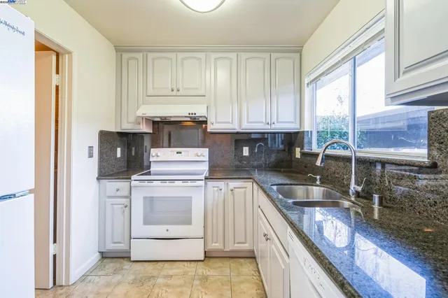 a kitchen with a stove a sink and a refrigerator