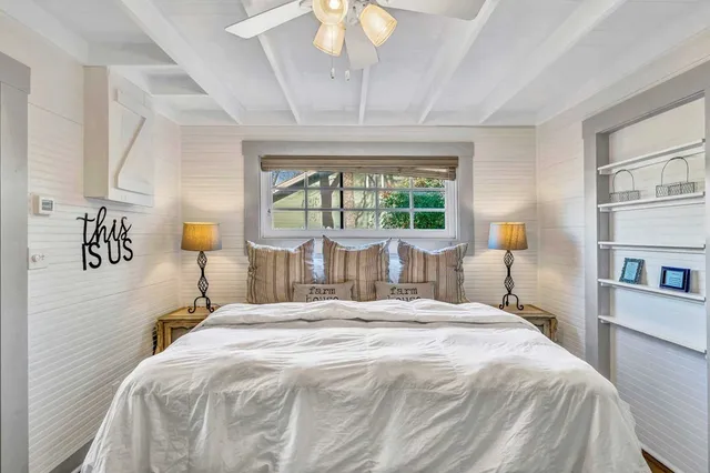 a bedroom with a large bed and a chandelier