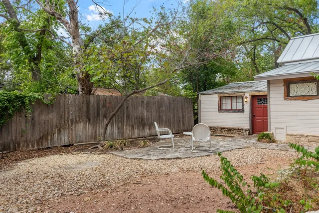 a backyard of a house with table and chairs