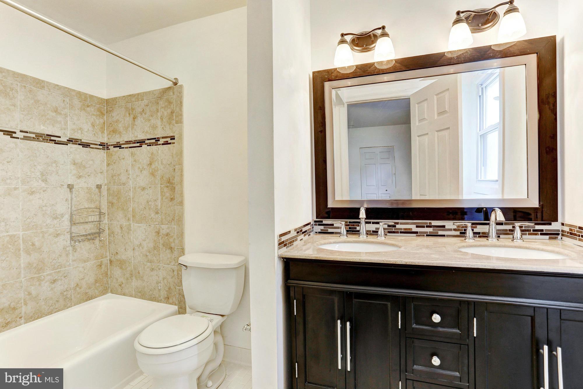 9405 Tulsemere Road Randallstown, MD 21133 - Photo 12 of 26 a bathroom with a sink vanity mirror and toilet