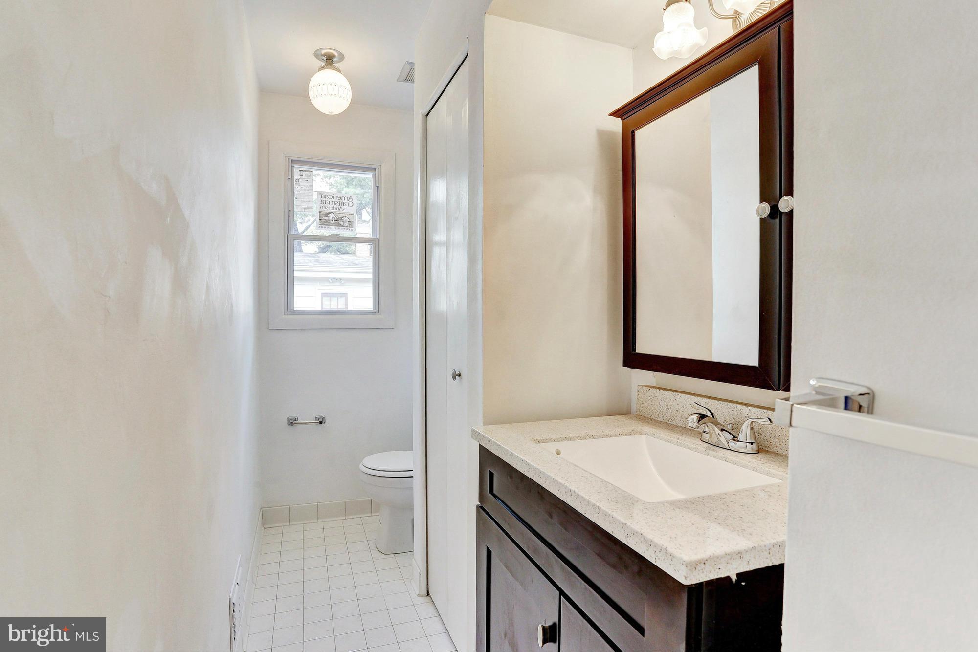 9405 Tulsemere Road Randallstown, MD 21133 - Photo 14 of 26 a bathroom with a granite countertop sink toilet and a mirror