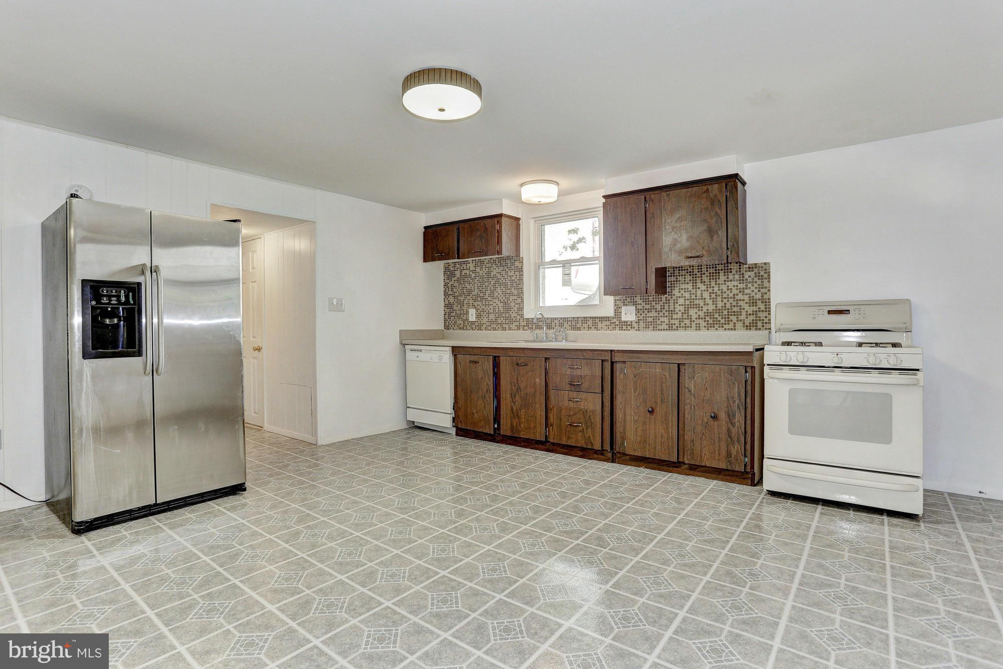 9405 Tulsemere Road Randallstown, MD 21133 - Photo 19 of 26 a kitchen with stainless steel appliances a white stove top oven and sink