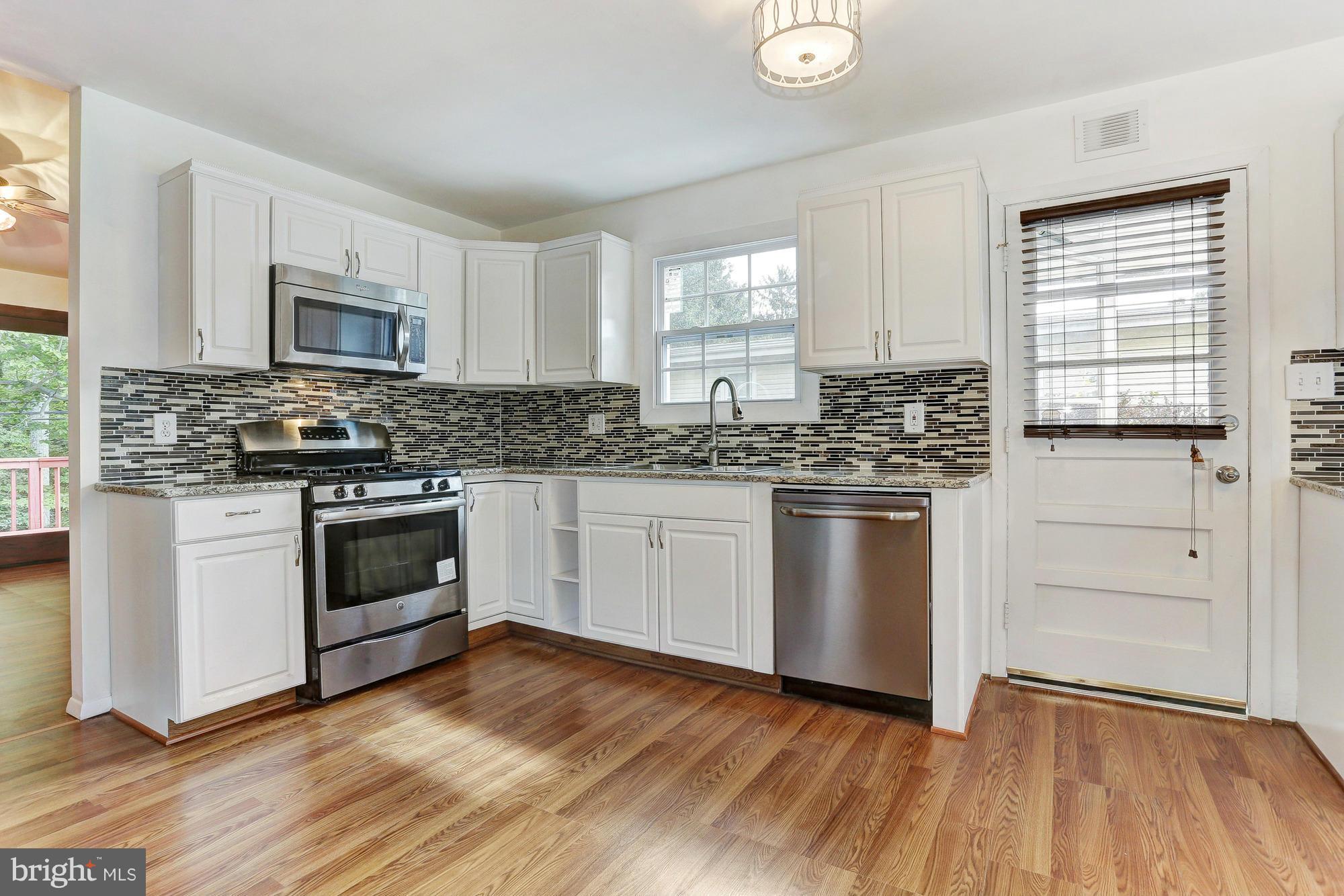 9405 Tulsemere Road Randallstown, MD 21133 - Photo 6 of 26 a kitchen with granite countertop stainless steel appliances a sink cabinets and a window