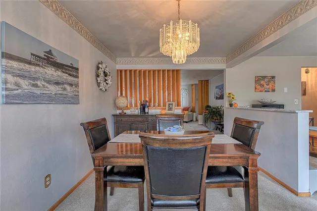 a dining room with furniture a chandelier and window