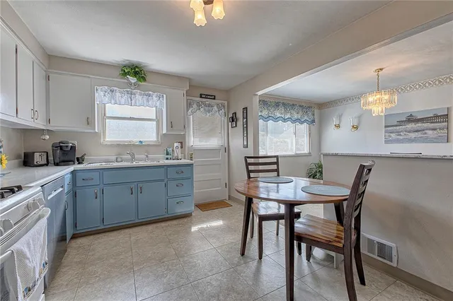 a kitchen with a table chairs sink and cabinets