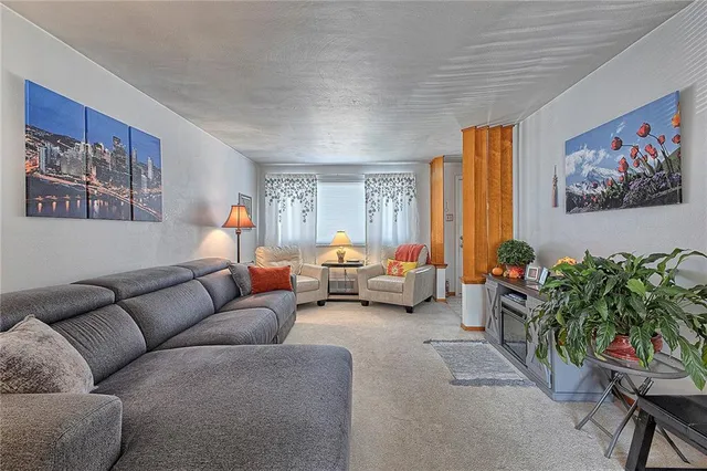 a living room with furniture a couch and a potted plant