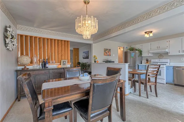 a dining room with furniture a chandelier and window