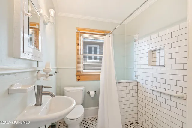 a bathroom with a sink a toilet and shower curtain