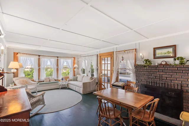 a living room with furniture a large window and wooden floor