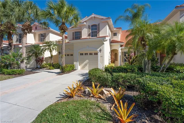 a front view of a house with a yard and potted plants
