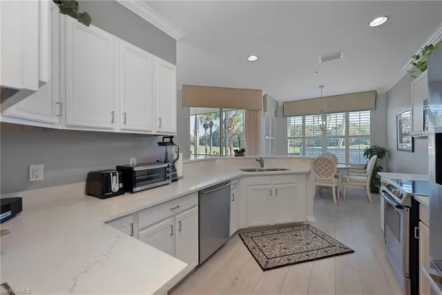 a kitchen with a sink a stove and white cabinets