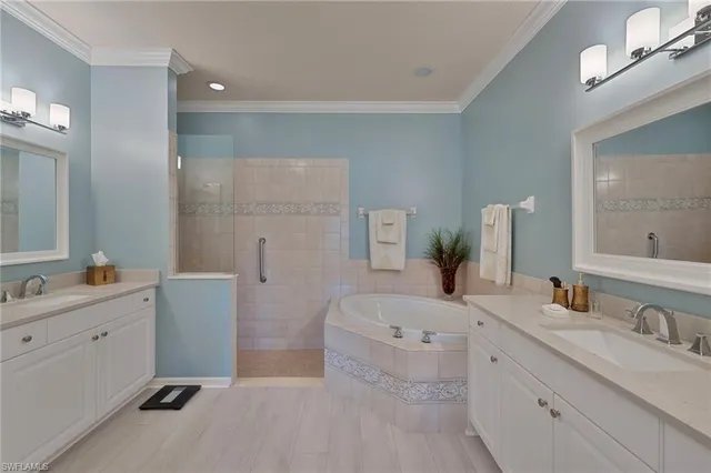 a bathroom with a double vanity sink mirror and bathtub