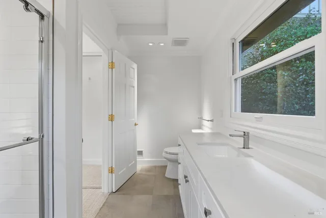 a bathroom with a sink a toilet and a large mirror