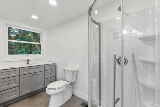 a bathroom with a toilet sink shower and mirror