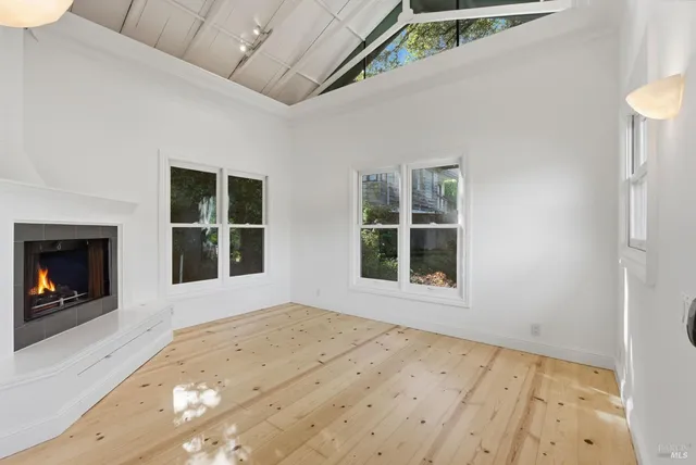 a view of an empty room with a window and fireplace